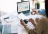 Inteligencia artificial: regular sí, pero con inteligencia Dos personas trabajan con dispositivos digitales y analizan información en una computadora, representando el uso responsable de la inteligencia artificial como herramienta de apoyo profesional.