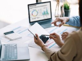 Inteligencia artificial: regular sí, pero con inteligencia Dos personas trabajan con dispositivos digitales y analizan información en una computadora, representando el uso responsable de la inteligencia artificial como herramienta de apoyo profesional.