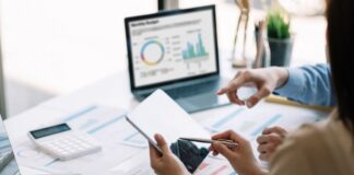 Inteligencia artificial: regular sí, pero con inteligencia Dos personas trabajan con dispositivos digitales y analizan información en una computadora, representando el uso responsable de la inteligencia artificial como herramienta de apoyo profesional.