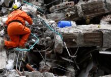 Colombia: la ideología se interpone entre la ayuda y las víctimas Rescatista busca sobrevivientes entre los escombros de una construcción colapsada tras un terremoto.