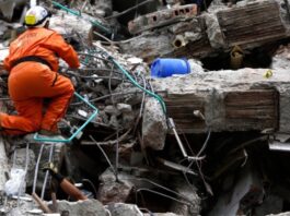Colombia: la ideología se interpone entre la ayuda y las víctimas Rescatista busca sobrevivientes entre los escombros de una construcción colapsada tras un terremoto.