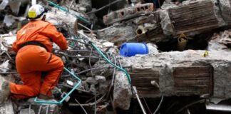 Colombia: la ideología se interpone entre la ayuda y las víctimas Rescatista busca sobrevivientes entre los escombros de una construcción colapsada tras un terremoto.