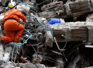 Colombia: la ideología se interpone entre la ayuda y las víctimas Rescatista busca sobrevivientes entre los escombros de una construcción colapsada tras un terremoto.