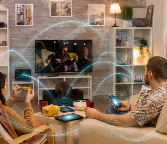 Su casa está llena de ondas que usted no puede ver Familia en una sala rodeada por una representación gráfica de las ondas inalámbricas emitidas y recibidas por teléfonos, router, televisión y otros dispositivos electrónicos.