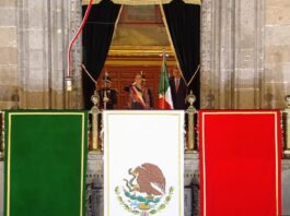 El Grito de Independencia: la historia detrás de una tradición de más de dos siglos Ceremonia del Grito de Independencia de 2026 desde el balcón central de Palacio Nacional, decorado con los colores de la bandera de México.