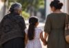 Mutilación genital femenina: una violación de derechos humanos convertida en tradición Tres generaciones de mujeres caminan juntas; una niña tomada de la mano de una mujer adulta, acompañada por una mujer mayor.