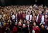 Morena aprueba alianzas para 2027 y pone en marcha su organización territorial Grupo numeroso de integrantes de Morena posa frente a cortinas negras; varias personas levantan las manos y muestran acreditaciones del partido.