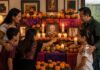 Día de Muertos: una tradición que reúne a las familias y a México Dos adultos y tres menores reunidos frente a una ofrenda con fotografías, flores de cempasúchil, veladoras, frutas y pan.