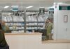 El faltante de medicamentos y las cifras manipuladas para desacreditar al sistema de salud en México Personal detrás de las ventanillas de una farmacia hospitalaria, con medicamentos organizados en anaqueles y una usuaria frente al mostrador.