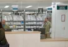 El faltante de medicamentos y las cifras manipuladas para desacreditar al sistema de salud en México Personal detrás de las ventanillas de una farmacia hospitalaria, con medicamentos organizados en anaqueles y una usuaria frente al mostrador.