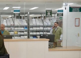 El faltante de medicamentos y las cifras manipuladas para desacreditar al sistema de salud en México Personal detrás de las ventanillas de una farmacia hospitalaria, con medicamentos organizados en anaqueles y una usuaria frente al mostrador.