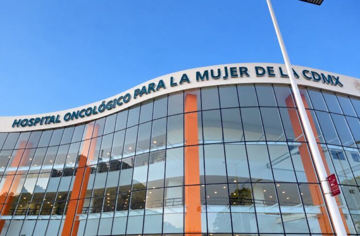 IMSS Bienestar incorpora inteligencia artificial para acelerar la atención del cáncer de mama Fachada de cristal del Hospital Oncológico para la Mujer de la Ciudad de México, con columnas anaranjadas y su nombre sobre la entrada.