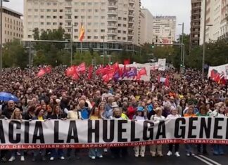 Sindicatos españoles anuncian huelga general por la crisis de vivienda Multitud en una manifestación por la vivienda, con banderas y una pancarta que llama a la huelga general.