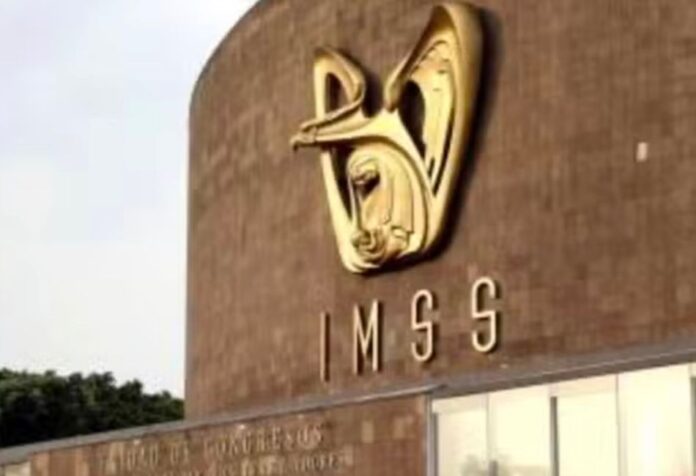 Emblema dorado y siglas del IMSS sobre la fachada de un edificio institucional.