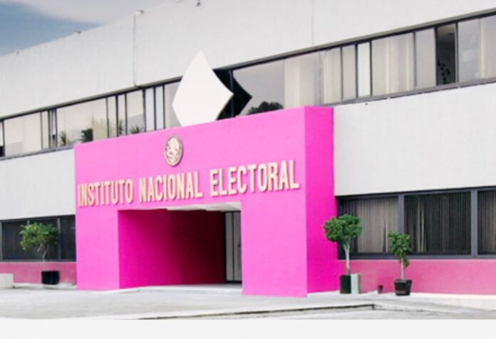 INE Fachada del Instituto Nacional Electoral, con entrada rosa, nombre institucional en letras doradas y ventanales.