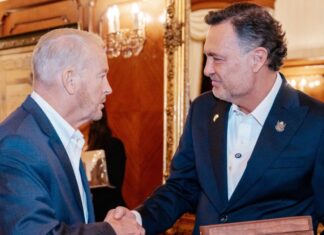 Los elogios de Ronald Johnson a Kuri que benefician políticamente al PAN queretano Ronald Johnson y Mauricio Kuri se estrechan la mano durante un encuentro en un salón.