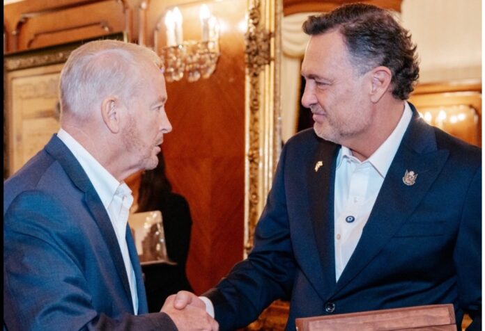 Johnson y Kuri Ronald Johnson y Mauricio Kuri se estrechan la mano durante un encuentro en un salón.