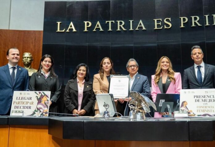 Ley catastral Grupo de legisladores posa en la Mesa Directiva del Senado mientras dos de sus integrantes sostienen un documento.