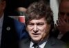 Milei en España: llama dictador, corrupto y ladrón al presidente español Javier Milei, con traje oscuro y corbata, rodeado de otras personas.