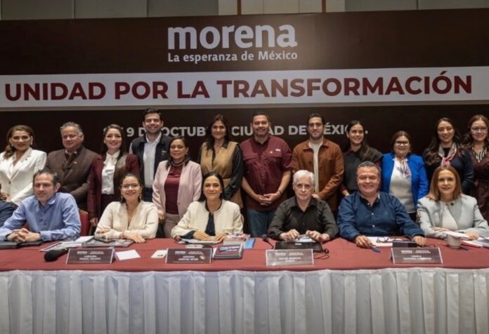 Ariadna Montiel y coordinadores estatales de Morena posan frente a una manta con el lema “Unidad por la transformación”.