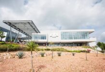 Universidades estadounidenses en México: el origen no garantiza la calidad Edificio universitario de fachada blanca y grandes ventanales, con una estructura metálica y jardines de plantas de zonas áridas.