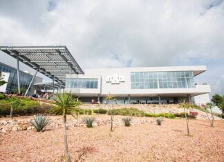 Universidades estadounidenses en México: el origen no garantiza la calidad Edificio universitario de fachada blanca y grandes ventanales, con una estructura metálica y jardines de plantas de zonas áridas.