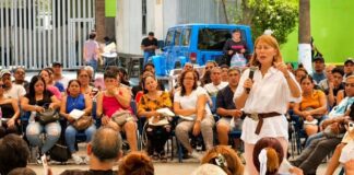 Tatiana busca cambiar la decisión de Morena en Nuevo León; sus cuestionamientos reciben respuesta Tatiana Clouthier, vestida de blanco, habla con un micrófono ante un grupo de personas sentadas en un espacio al aire libre.