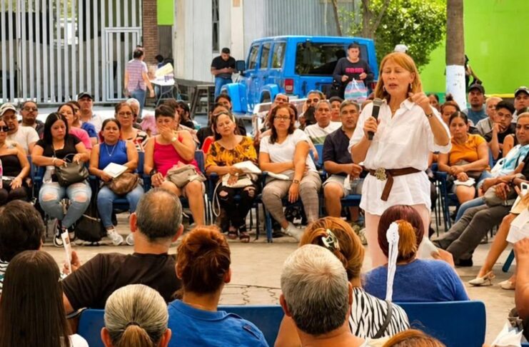 Tatiana busca cambiar la decisión de Morena en Nuevo León; sus cuestionamientos reciben respuesta Tatiana Clouthier, vestida de blanco, habla con un micrófono ante un grupo de personas sentadas en un espacio al aire libre.